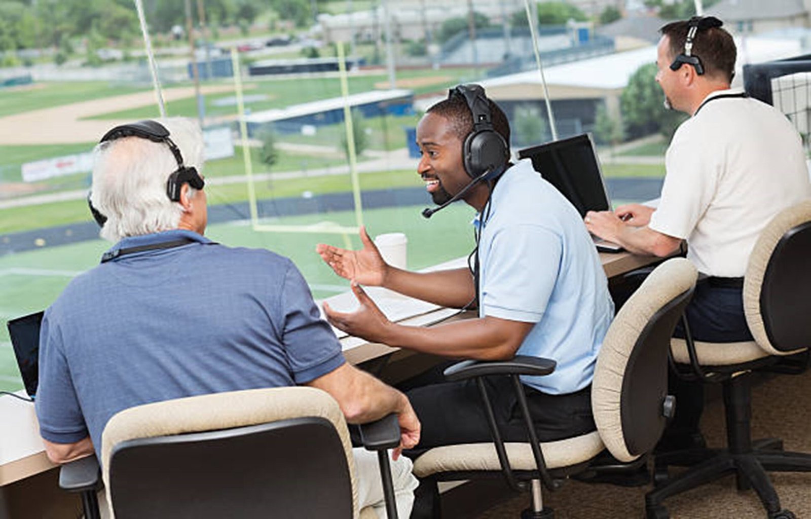 A group of football reporters sitting at a desk